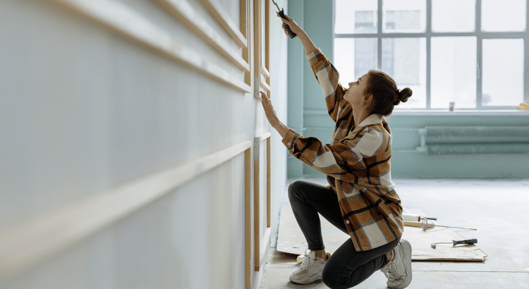Lady painting the exterior of her house.