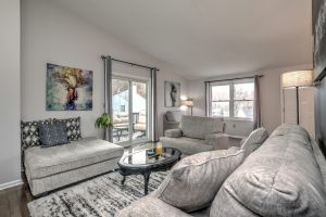 Bright living room with vaulted ceilings and slider to deck