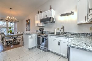 Updated kitchen and dining area with granite countertops and chandelier
